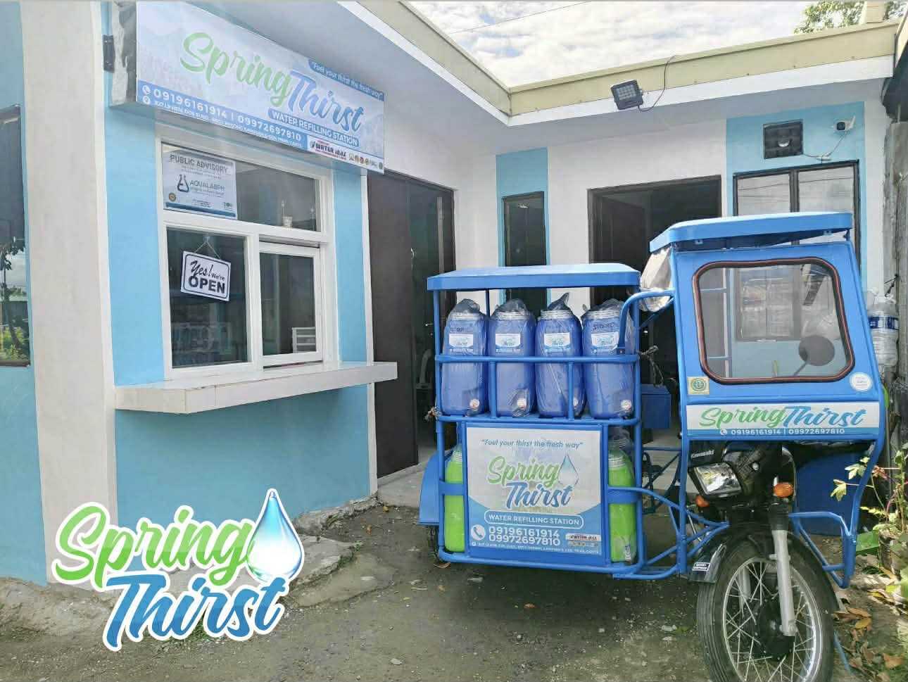 Spring Thirst Water Refilling Station storefront with branded delivery tricycle